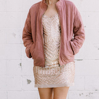 Mauve quilted jacket over a gold and cream sequin dress.