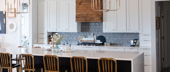Kitchen with a mix of various woods, different metals, and home accents in cream, white, black, and gold create a modern farmhouse interior style by Lauren and Janelle from Stone + Suede.