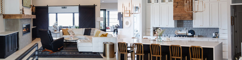 Two images of a livingroom and kitchen in a newly constructed home styled with white, black, gold, and wood accents in a modern farmhouse style by Lauren and Janelle from Stone + Suede.